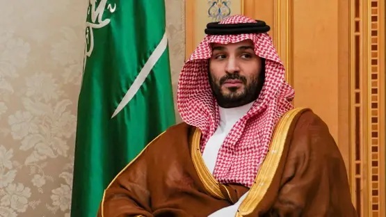 His Royal Highness Mohammed bin Salman in front of the flag of Saudi Arabia